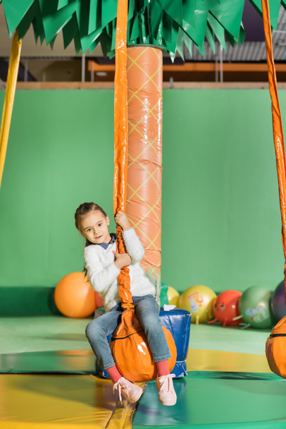 cute little kid swinging on swing in entertainment center - Foto, afbeelding