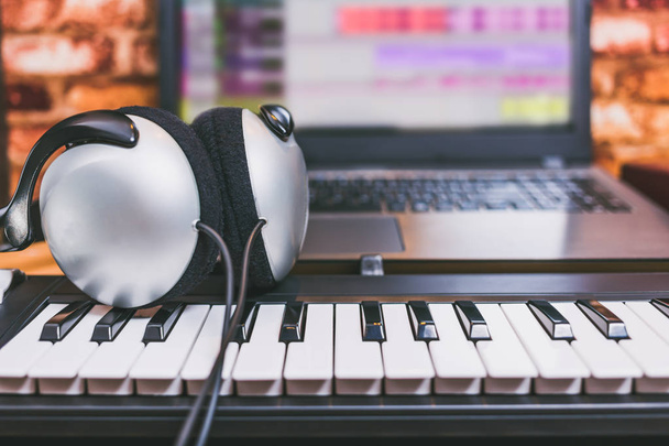 headphone on midi keyboard. computer music. recording & home studio concept - 写真・画像