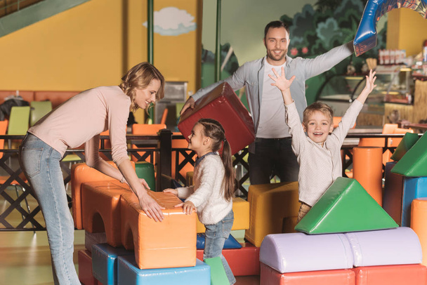 ευτυχισμένη οικογένεια παίζει με πολύχρωμο μπλοκ στο κέντρο ψυχαγωγίας  - Φωτογραφία, εικόνα