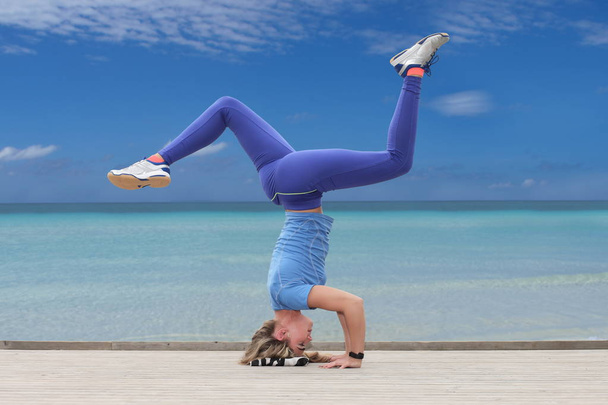Mujer haciendo yoga junto al mar
 - Foto, Imagen