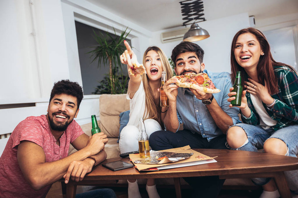 Grupo de jóvenes amigos comiendo pizza.Fiesta en casa.Concepto de comida rápida
. - Foto, imagen