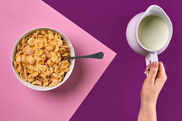 Comida, alimentação saudável, pessoas e conceito de dieta - close-up de mulher comendo muesli com leite para o café da manhã sobre fundo roxo e rosa
 - Foto, Imagem