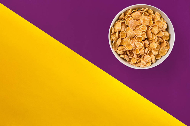 Bowl with cornflakes on the colorful background - Фото, зображення