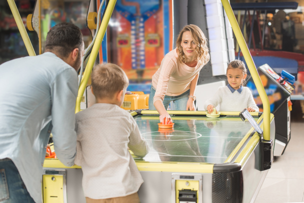glückliche Familie spielt gemeinsam Airhockey im Unterhaltungszentrum   - Foto, Bild