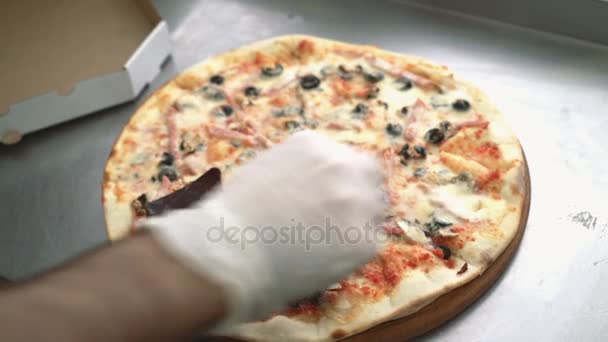 シェフの手は、レストランのキッチンでピザを調理後、ピザにスパイスを追加します。調理食品. - 映像、動画