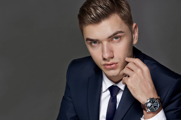 portrait of a man sitting with a suit with a watch, studio - Foto, afbeelding