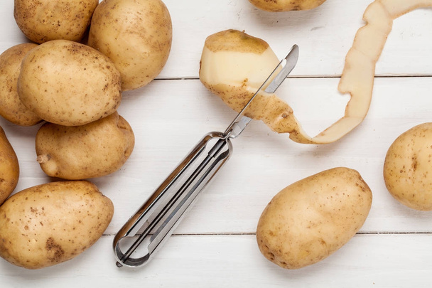 Raw potato on wooden background. - Фото, зображення