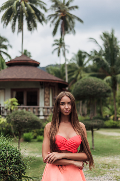 attractive girl on tropical resort with bungalow and palms - Foto, Imagem