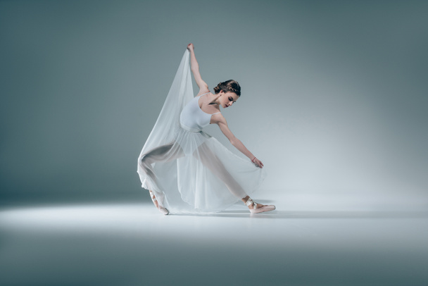 elegáns, fehér ruhában táncoló gyönyörű balerina - Fotó, kép