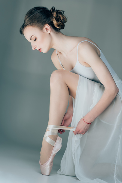 ballerina wearing ballet shoes on feet, isolated on grey - Photo, Image