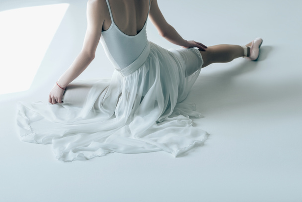 oříznutý pohled elegantní baletka sedící v bílých šatech - Fotografie, Obrázek