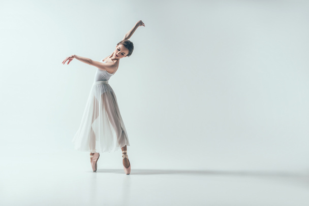 白で隔離、スタジオで踊る優雅なバレリーナ - 写真・画像