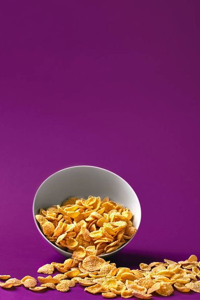 Schale mit Cornflakes auf dem bunten Hintergrund - Foto, Bild