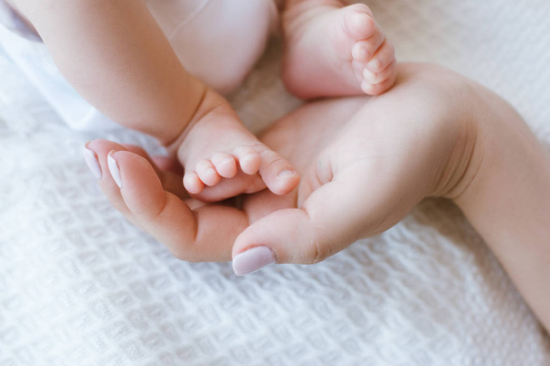 mother holds legs newborn baby - Valokuva, kuva