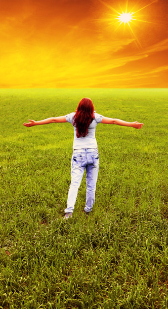 ευτυχισμένη γυναίκα να στέκεται στο πεδίο καταπράσινη. Τα χέρια ψηλά. πίσω όψη ενός έφηβου κοριτσιού - Φωτογραφία, εικόνα