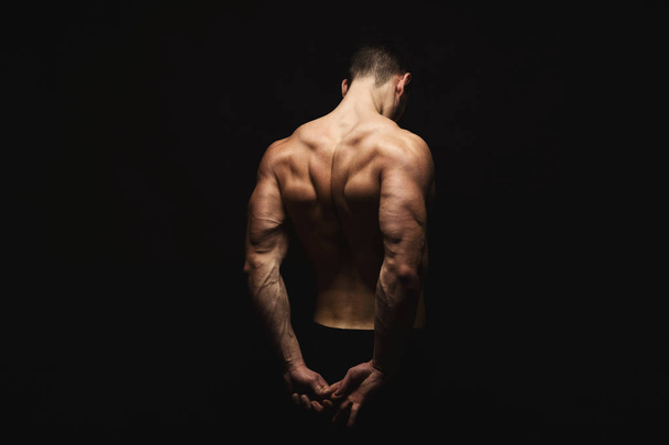 Unrecognizable man shows strong back muscles closeup - Foto, Imagen