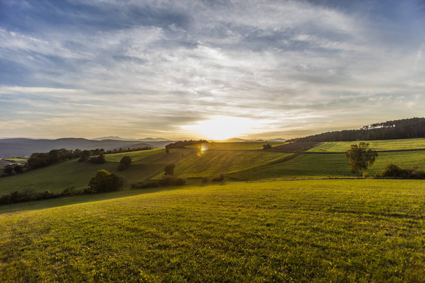 Tepelerin üzerinde güzel bir gün batımı. Doğanın günbatımı arka planı - Fotoğraf, Görsel
