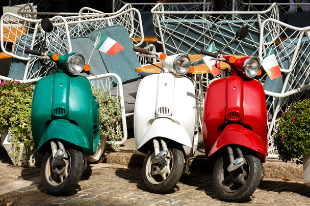 drie vintage scooter Italiaanse vlag kleuren geparkeerd op een stad stree - Foto, afbeelding
