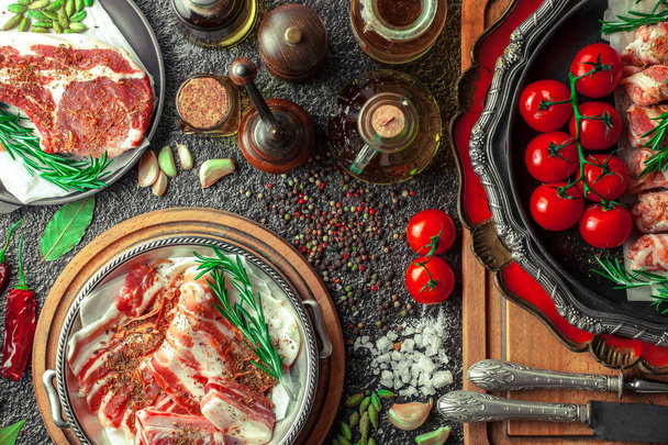 Viande crue sur la table de cuisine sur fond métallique dans une composition avec accessoires de cuisine
 - Photo, image