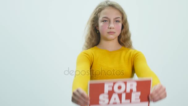 the girl shows a sign "for SALE" - Кадри, відео