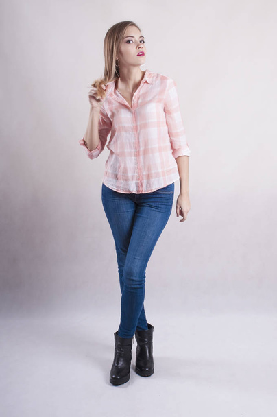 beautiful girl in a shirt and jeans studio - Foto, afbeelding