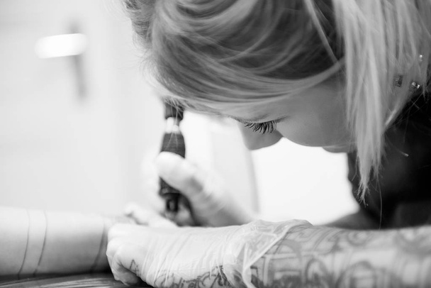 femme tatouant une autre femme
 - Photo, image