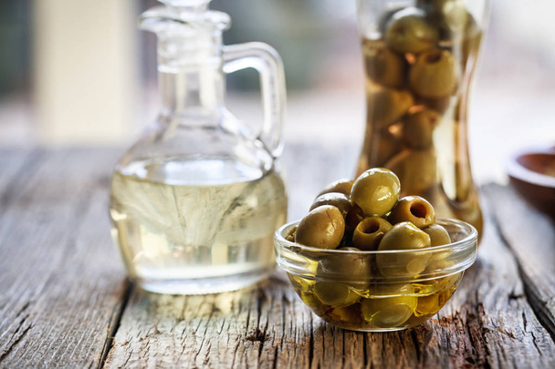 Olives and olive oil on a wooden table - Fotografie, Obrázek