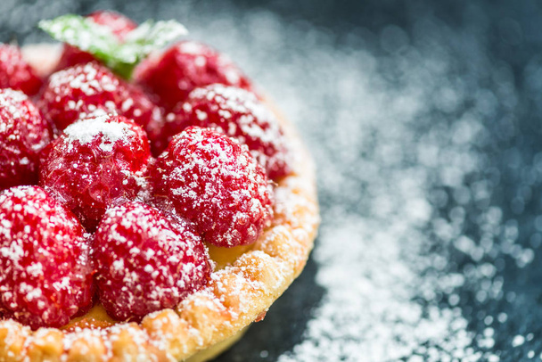 Raspberry Tarts with Mint Leaves and covered with Icing Sugar on Dark Background - Foto, Imagen