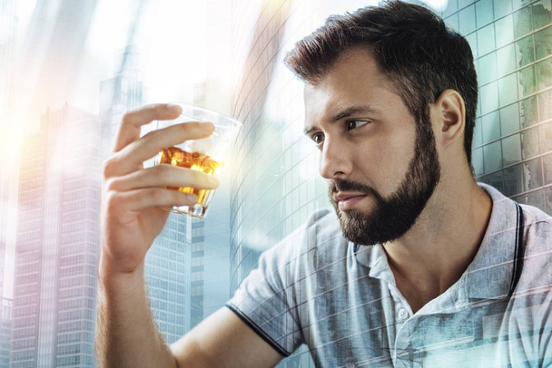 Thoughtful man sitting and looking at the alcohol in his glass - Foto, immagini