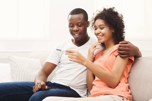 junges afrikanisch-amerikanisches Paar freut sich über Ergebnisse des Schwangerschaftstests - Foto, Bild
