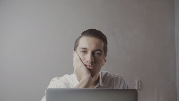 Giovane, uomo d'affari annoiato con computer portatile seduto al tavolo in ufficio
 - Filmati, video