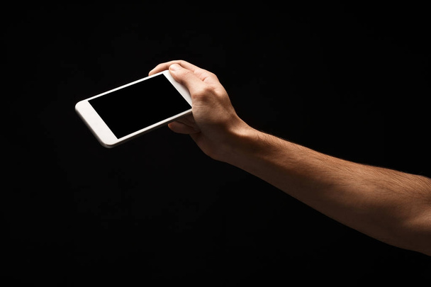 Male hand holding mobile smartphone with blank screen - Foto, afbeelding