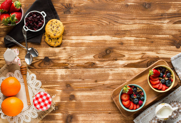 Cereal. Breakfast with muesli, and fresh fruits in bowls on a rustic wooden background, free space for text - Fotoğraf, Görsel