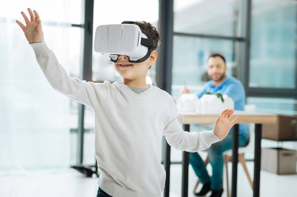 Pleasant boy playing with VR headset at fathers work - Фото, зображення