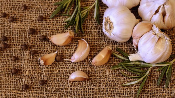 Garlic and cloves lying on a napkin. Healthy food and spices. Ad - Zdjęcie, obraz