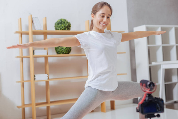 Positive blogger smiling to the camera while practicing yoga - Zdjęcie, obraz