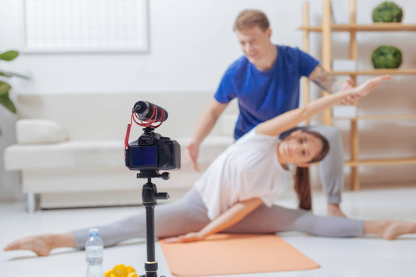 Skilled trainer showing his assistant bending in front of the camera - Foto, imagen