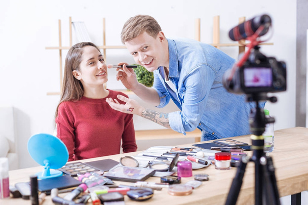 Красивый мужчина помогает молодой женщине с макияжем
 - Фото, изображение