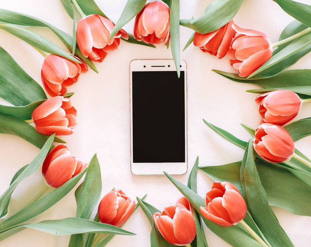 Le fond avec des tulipes rouges et un téléphone dessus
 - Photo, image
