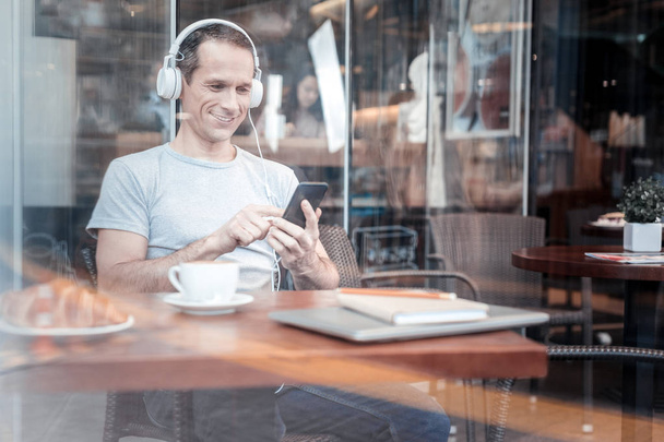 Positive delighted man typing message - 写真・画像
