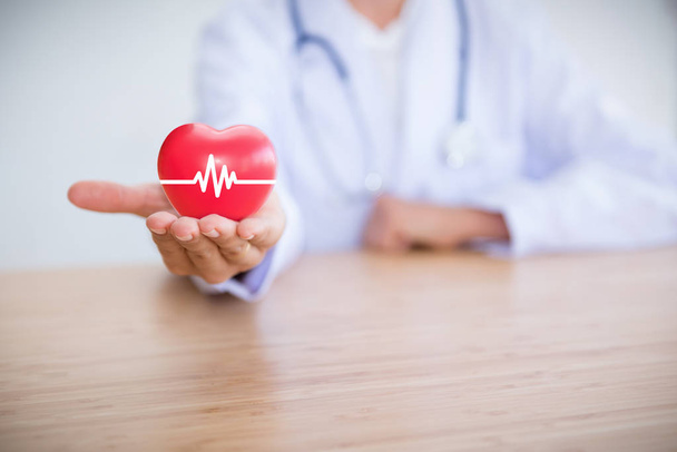 Kadın doktor stetoskop giyen ve kırmızı kalp, tıp holding - Fotoğraf, Görsel