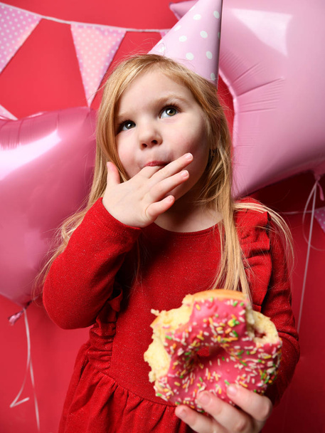 Menina bonita adorável com balões rosa e presente vermelho e boné de aniversário
 - Foto, Imagem
