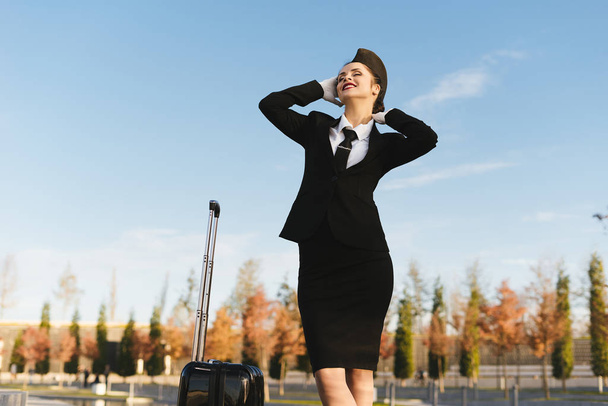 happy woman stewardess in uniform on blue sky background - 写真・画像