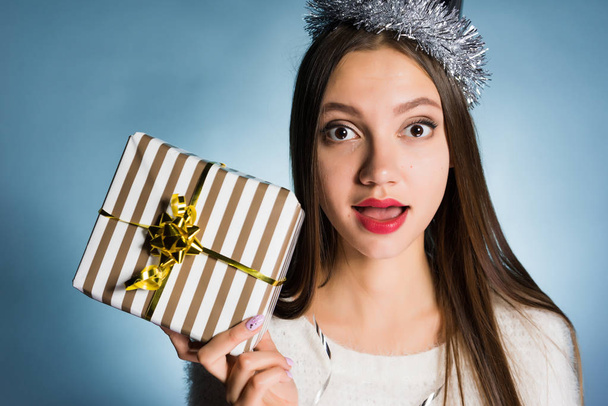 surprised woman in a festive hat holds a gift in her hands - Photo, Image