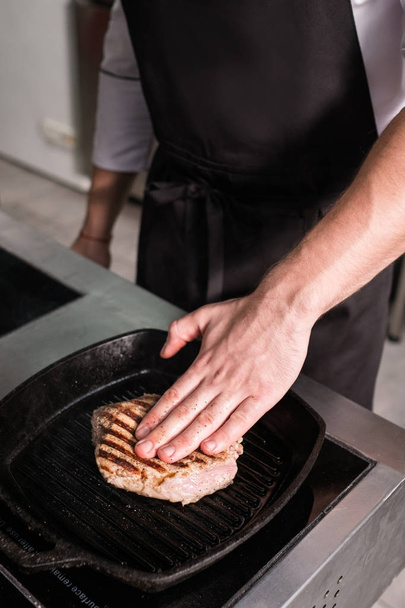 chef works restaurant kitchen preparing meat - Foto, Imagem