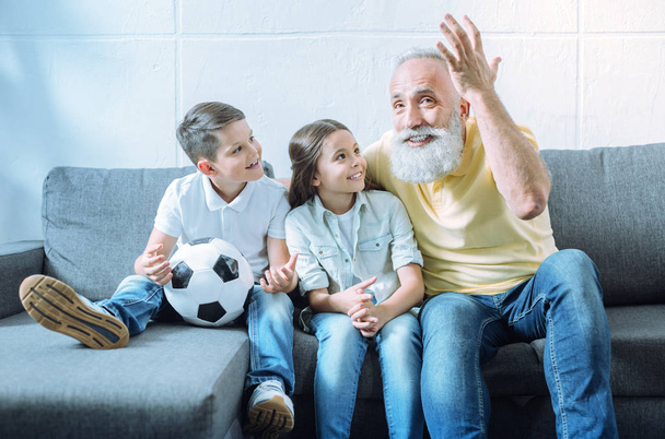 Excited grandfather telling children interesting story - 写真・画像