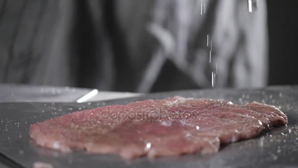 Put the salt. Wiener schnitzel . Raw pork ready for marinade with oil. Cooking with fire in frying pan. Professional chef in a kitchen of restaurant cooking. - Záběry, video
