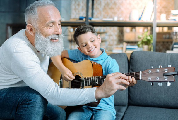 Loving granddad teaching child playing guitar - Φωτογραφία, εικόνα