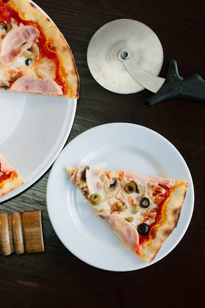 Vista superior da fatia de pizza na placa branca sobre a mesa
 - Foto, Imagem