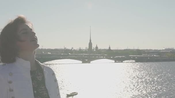 Ελκυστική νεαρή κοπέλα σε λευκό σακάκι στον τελευταίο όροφο με γραφική θέα στον ποταμό - Πλάνα, βίντεο